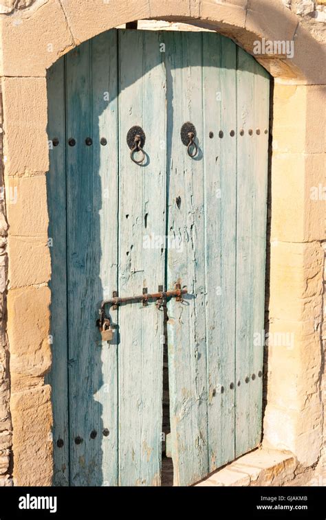 Old Blue Shabby Wooden Door With Rusty Hinges At The Entrance Of