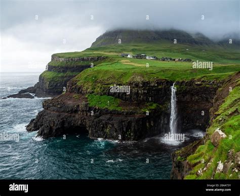 Faroe Islands Múlafossur Waterfall And Gasadalur Village Over The The