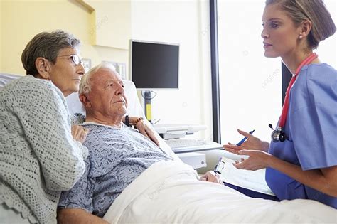 Nurse Talking To Senior Couple In Hospital Room Background Room