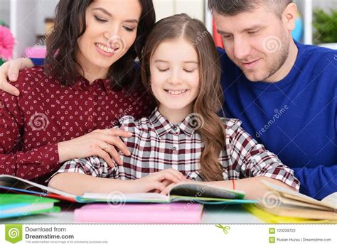 Parents And Daughter Doing Homework In Room Stock Photo Image Of