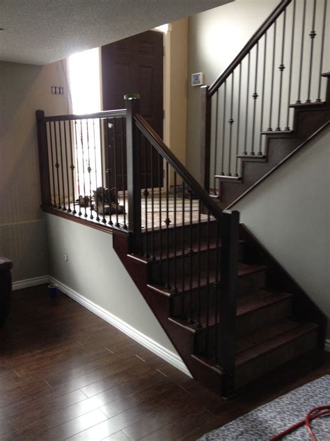 There comes a time when your staircase banisters need a makeover. Stained maple railing renovation with black metal spindles ...