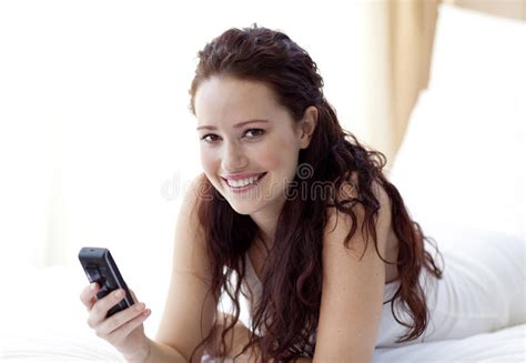 A Mulher De Sorriso Na Noite Que Encontra Se Na Cama Usa Smartphone