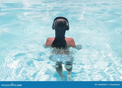 woman in the headphones listening to the music bathing in a pool stock image image of