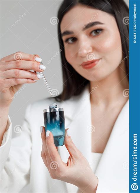 Young Cosmetologist Sitting On A White Sofa In A Studio With Cosmetics