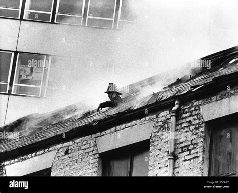 A Firefighter Pokes His Head Through The Roof Of The Smoke Filled