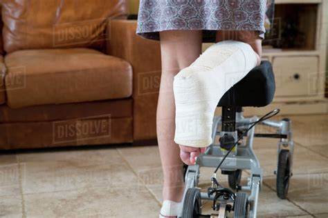 Close Up Of Woman With Leg In Plaster Cast At Home Using Mobility Aid