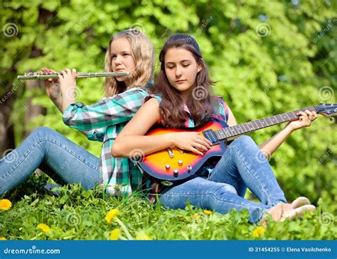 Two Girls Playing Guitar And Flute In The Park Stock Image Image Of