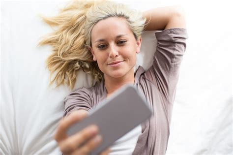 Free Photo Portrait Of Smiling Woman Taking Selfie In Bed