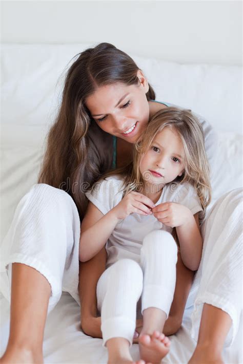 Portrait Of A Mother And Her Daughter Posing On A Bed Royalty Free