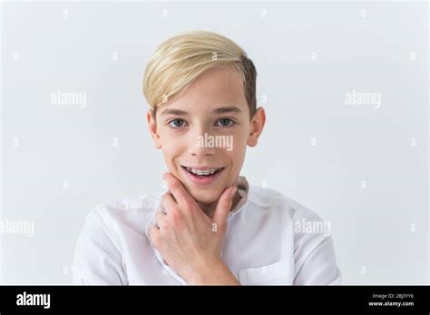 Close Up Of Teen Boy With Braces On Teeth Smiling On White Background