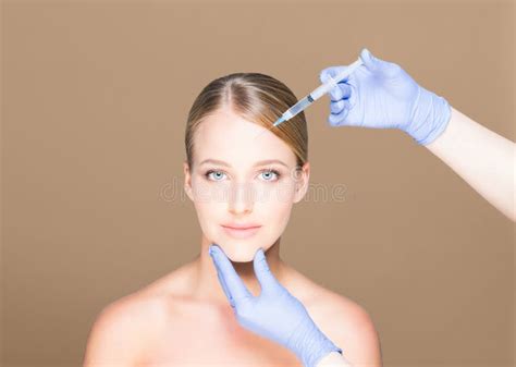 Young And Beautiful Woman Having Skin Injections Over Brown Background Plastic Surgery Concept