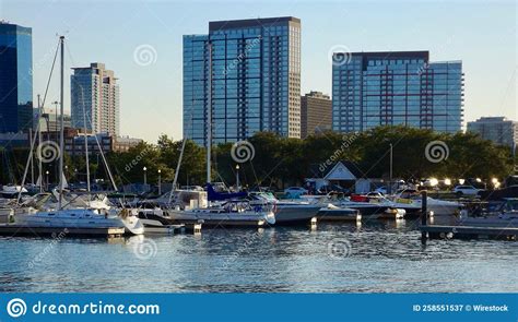 Boats Docked At Harbor With Trees And Buildings In The Background