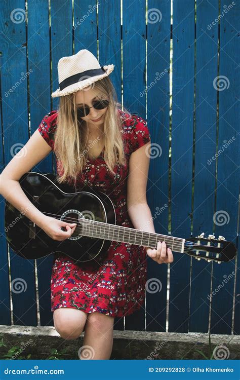 Beautiful Teenage Blonde Long Haired Girl Playing Acoustic Guitar