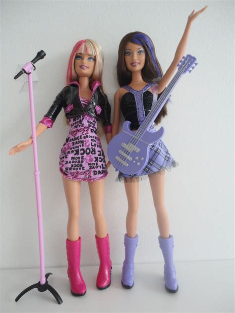 Two Barbie Dolls Standing Next To Each Other With Guitars And