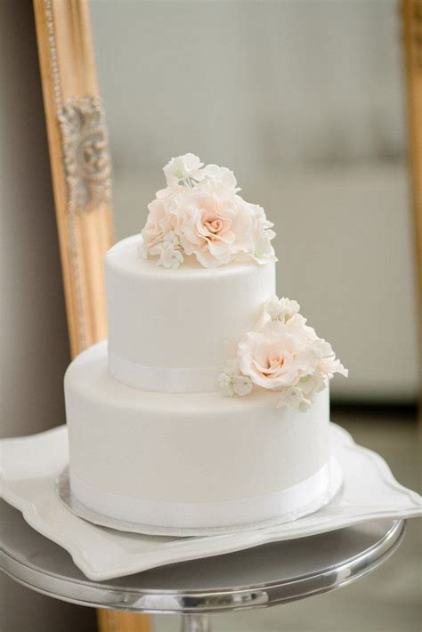 stunning white cake with flower topper and detail white on white glamorous wedding ideas by env