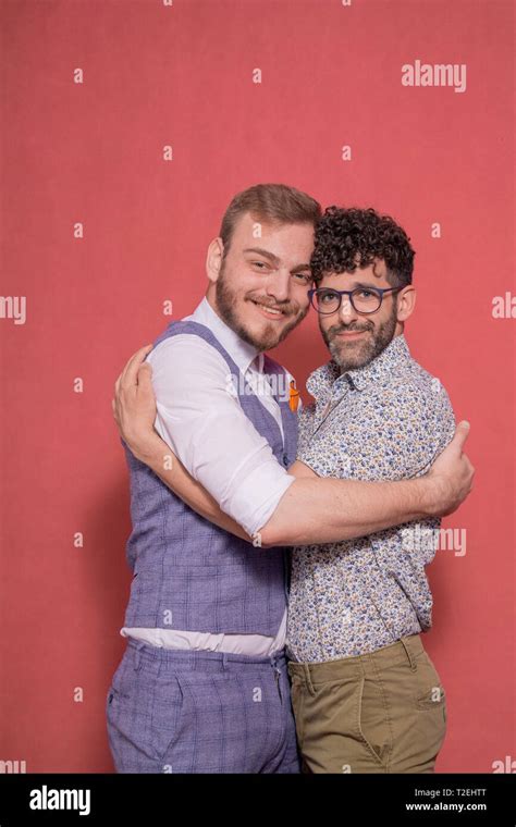 Two Men Gay Couple Hugging And Posing In Studio Looking To Camera
