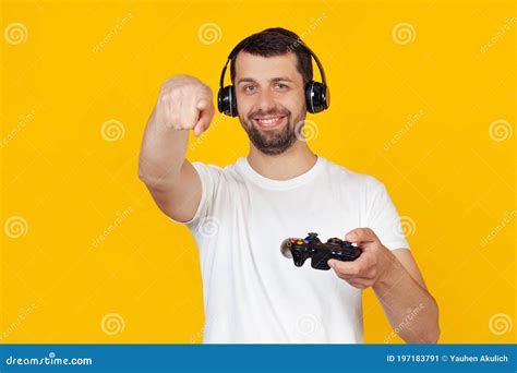 Young Man With A Beard In A White T Shirt Smiling Gamer Playing Video