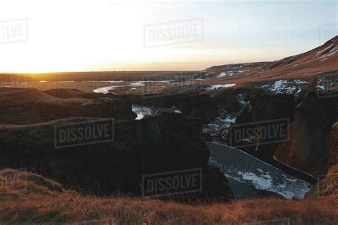 Scenic Icelandic Landscape With River And Snow On Hills At Sunrise