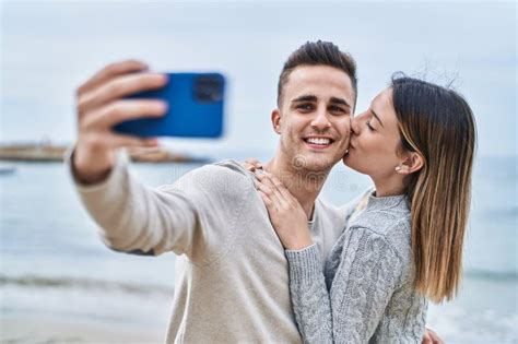 Man And Woman Couple Make Selfie By Smartphone Kissing At Seaside Stock