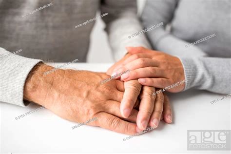 Close Up Of Young Woman Holding Senior Man Hands Stock Photo Picture