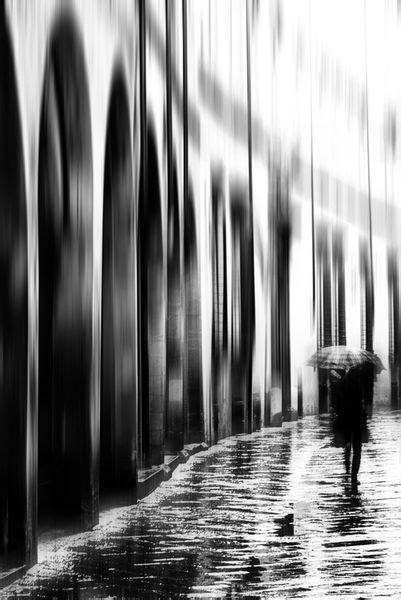 Black And White Photograph Of People Walking In The Rain With An Umbrella