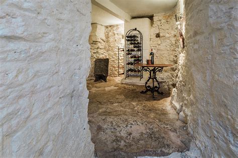 To obtain the above ideal wine cellar conditions, you can either choose a location with favorable existing conditions (root cellar, unconditioned basement, etc.) or actively create these conditions yourself by building a wine cellar. Wine Cellar In The Basement Of An Old House | Stocksy United