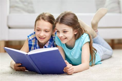 Two Happy Girls Reading Book At Home Stock Photo Image 56097592