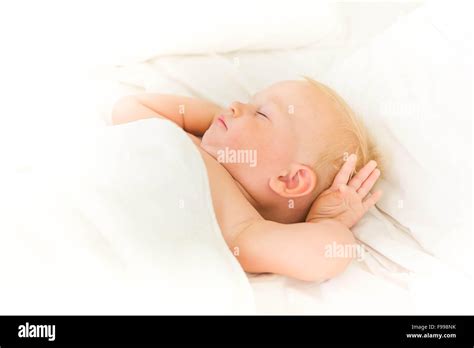 Peaceful Baby Lying On A Bed Sleeping On White Sheets Stock Photo Alamy