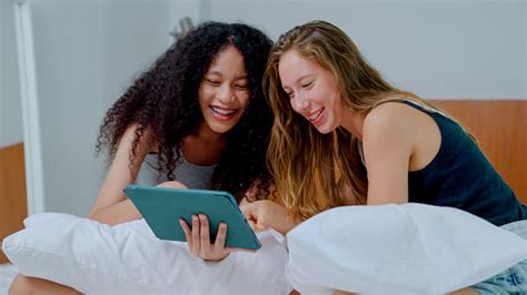 pasangan lesbian muda menggunakan browsing media sosial sambil menginap di hotel mewah foto stok