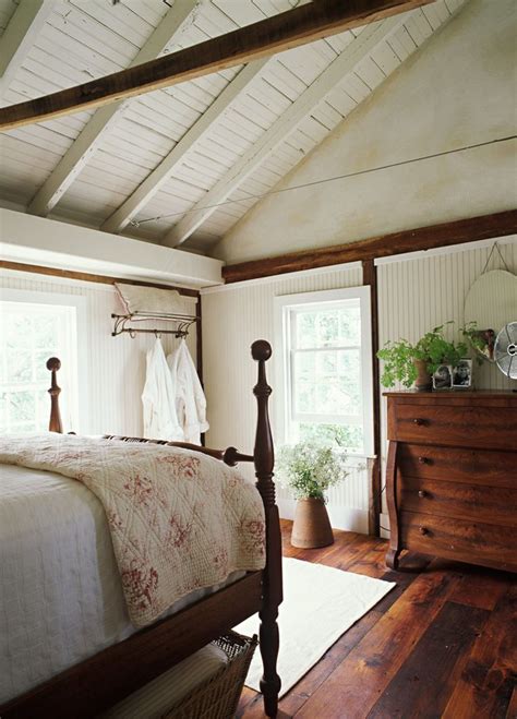 A Country Cottage Master Bedroom With Dark Hardwood Floors And Vaulted