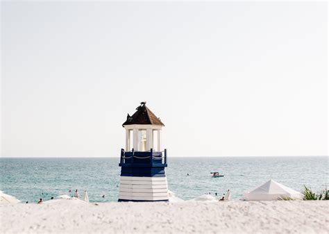 Photo Of Blue And White Painted Lighthouse Near The Beach · Free Stock
