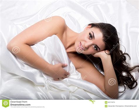 Pretty Female In Peignoir Sleeping On Bed Under Silk Sheets Stock