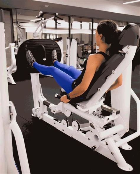 A Woman Is Sitting In A Gym Chair With Her Leg Up On The Bench And