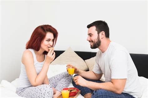 Free Photo Smiling Young Couple Having Breakfast In Bedroom