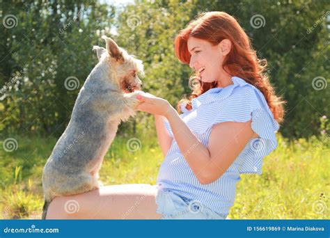 Una Jovencita Alegre Sentada Y Abrazando A Su Perro En La Naturaleza Imagen De Archivo Imagen