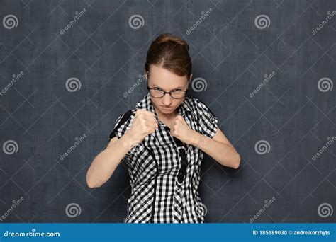 Portrait Of Focused Young Woman Holding Fists Clenched In Front Of Her