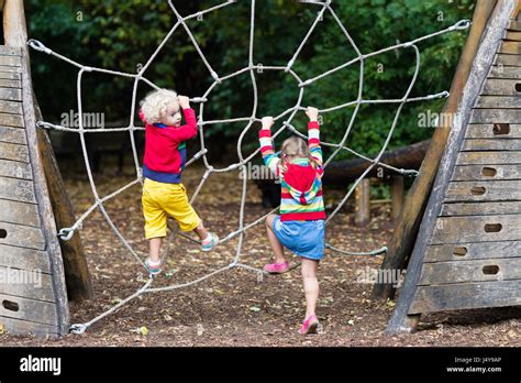 Active Children Playing On Climbing Net At School Yard Playground Kids