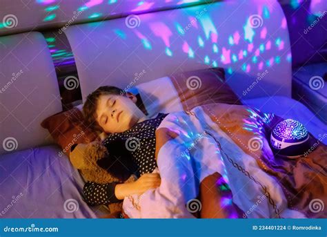 Little Kid Boy Sleeping In Bed With Colorful Lamp School Child