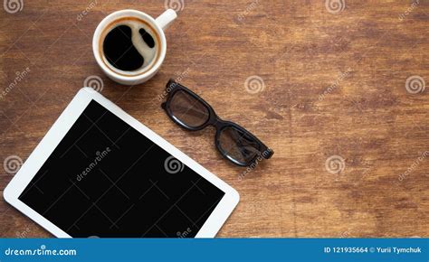 Tablet Pc Looking Like Ipad On Wood Table With Coffee And Black Glasses