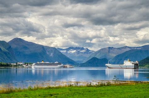 Sailing Ship And Ferry On A Norway Fjord With Mountains Behind And