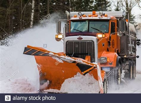 An Orange Snowplow Plows Through Deep Snow In The Woods Stock Image