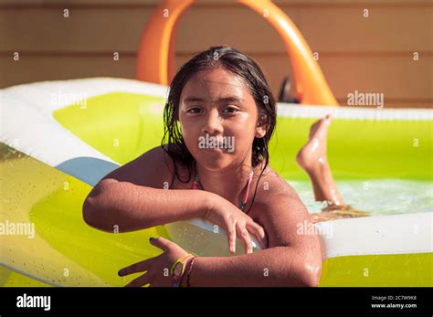 Girl In Swimming Pool Looking At Camera A Backyard Pool Party At Home