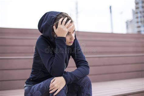 Worried Sad And Depressing Young Woman Sits Outside Stock Image