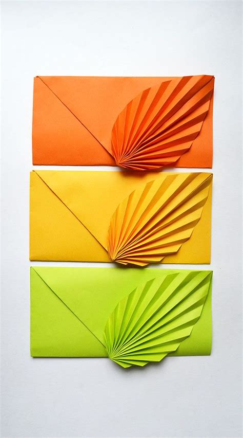 Three Different Colored Papers Folded In The Shape Of An Origami Fan On