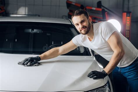 Positive Good Looking Mechanic Cleaning The Surface Of His Car Stock