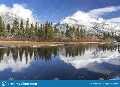 Snowy Mountain Peaks And Green Forest Trees Landscape Reflections In