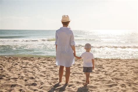 Opinión Trasera La Madre Y El Hijo En La Playa En El Día Soleado
