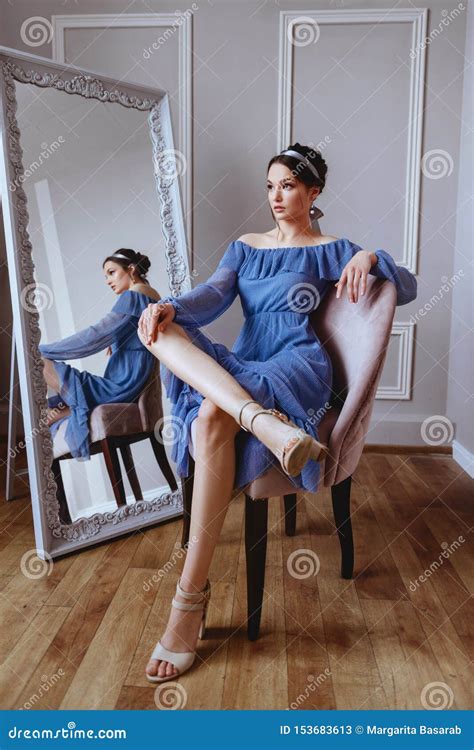une belle femme dans une robe bleue s assied sur un fauteuil de velours image stock image du