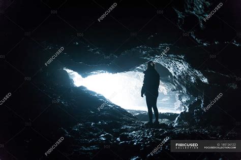 Silhouette Standing By Cave Entrance — Copy Space Horizontal Stock