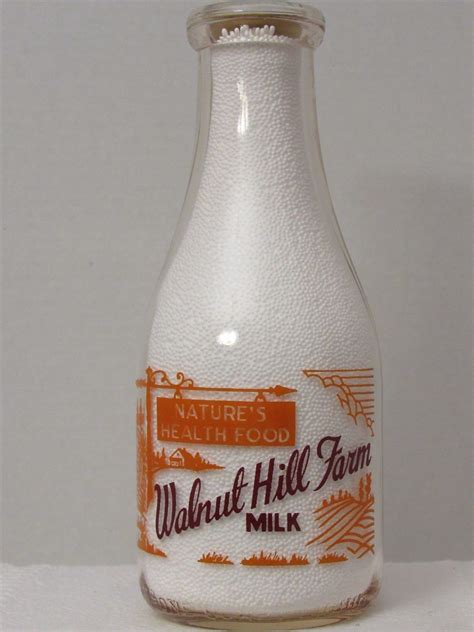 A Glass Bottle Filled With Milk Sitting On Top Of A Table